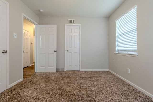 unfurnished bedroom featuring dark carpet