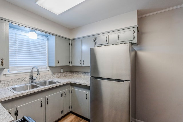 kitchen with gray cabinets, light hardwood / wood-style flooring, stainless steel refrigerator, and sink