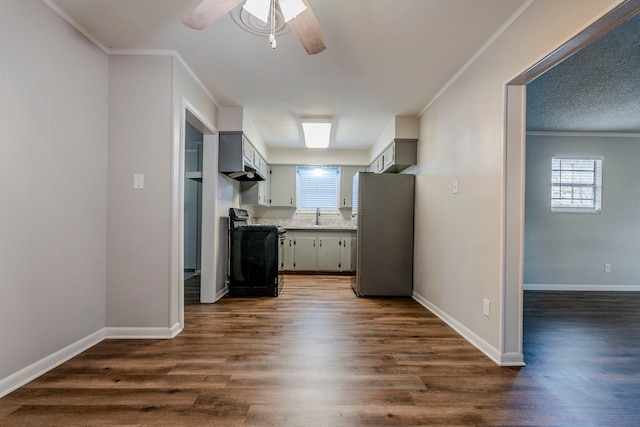 kitchen featuring gray cabinets, stove, and stainless steel refrigerator