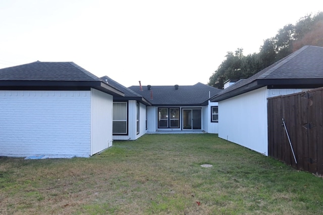 rear view of house featuring a yard