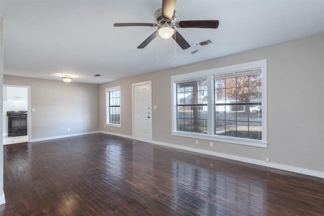 unfurnished living room featuring dark wood-type flooring and ceiling fan