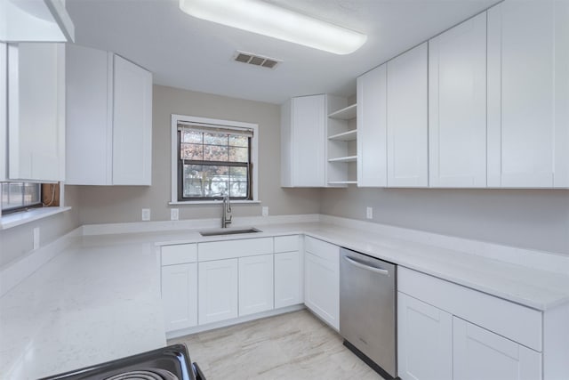 kitchen featuring white cabinetry, stainless steel dishwasher, sink, and light stone counters