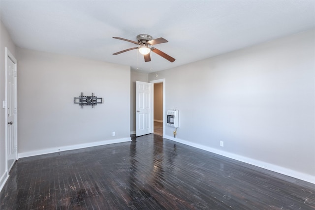 spare room featuring heating unit, dark hardwood / wood-style flooring, and ceiling fan