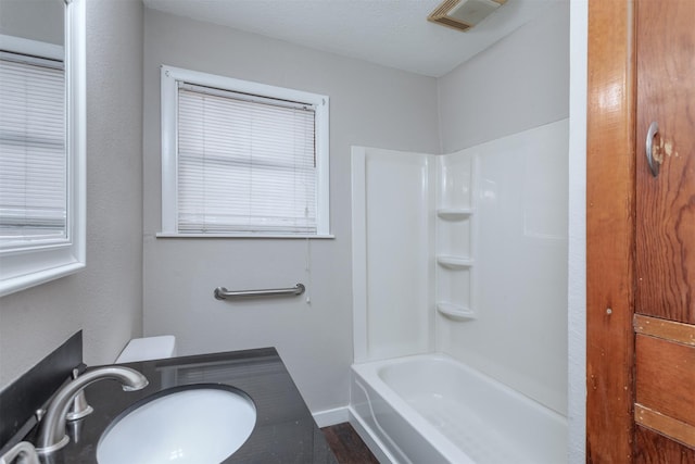 bathroom with vanity, shower / bathing tub combination, a textured ceiling, and wood-type flooring