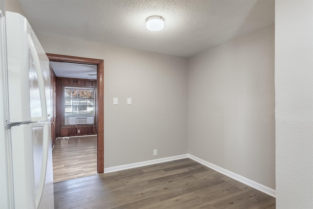 spare room with cooling unit, dark wood-type flooring, and a textured ceiling