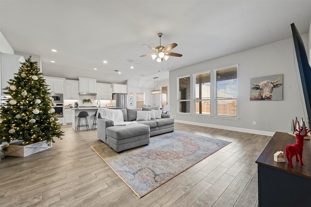 living room with light hardwood / wood-style flooring and ceiling fan