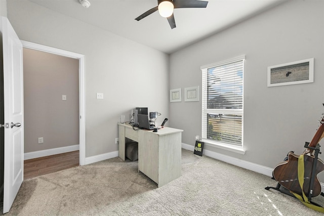 carpeted office space with ceiling fan