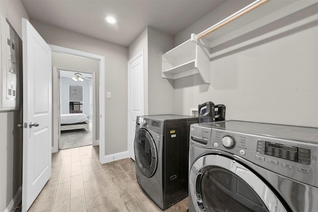 laundry room with ceiling fan, washing machine and dryer, and light hardwood / wood-style flooring