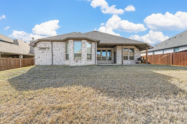 rear view of property with a lawn