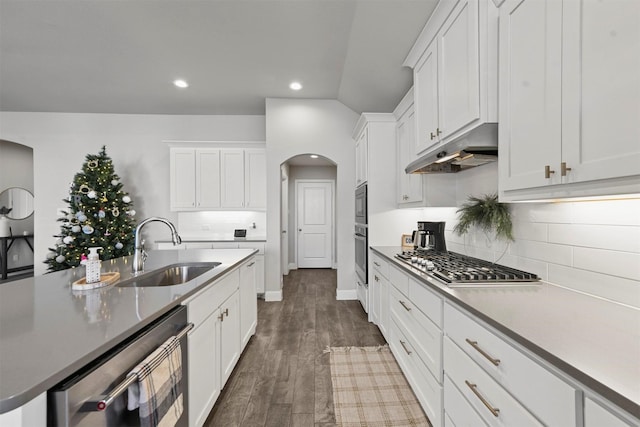 kitchen featuring sink, stainless steel gas cooktop, tasteful backsplash, dark hardwood / wood-style flooring, and white cabinets