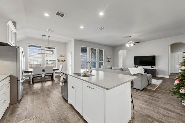 kitchen with appliances with stainless steel finishes, a kitchen island with sink, sink, and white cabinets