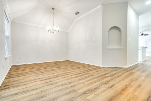 empty room with light hardwood / wood-style floors, ornamental molding, and vaulted ceiling