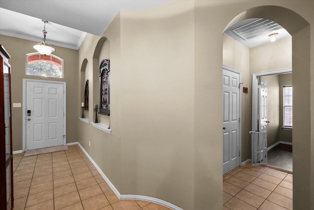 tiled entryway featuring ornamental molding