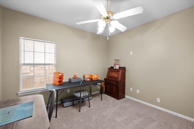 carpeted home office featuring ceiling fan