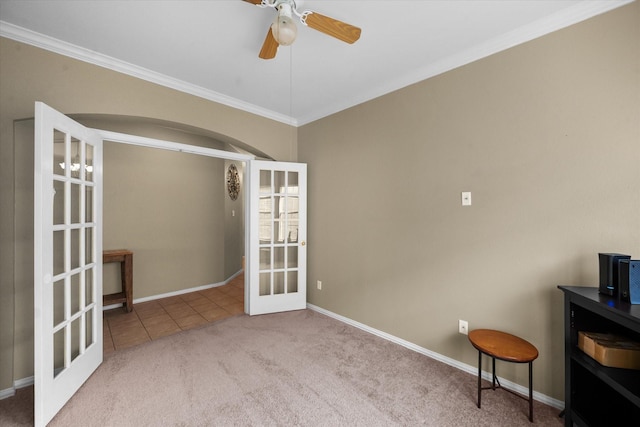 carpeted empty room with crown molding, ceiling fan, and french doors