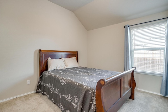 bedroom with light carpet and lofted ceiling