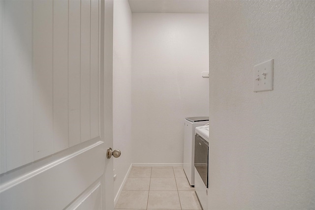 laundry room with washer and clothes dryer and light tile patterned floors