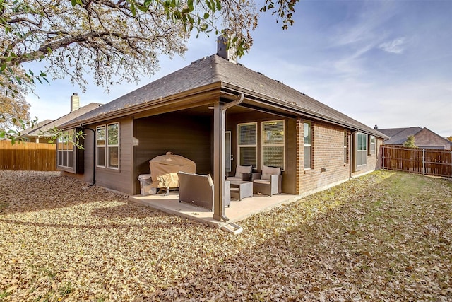 rear view of property featuring a patio area and an outdoor hangout area