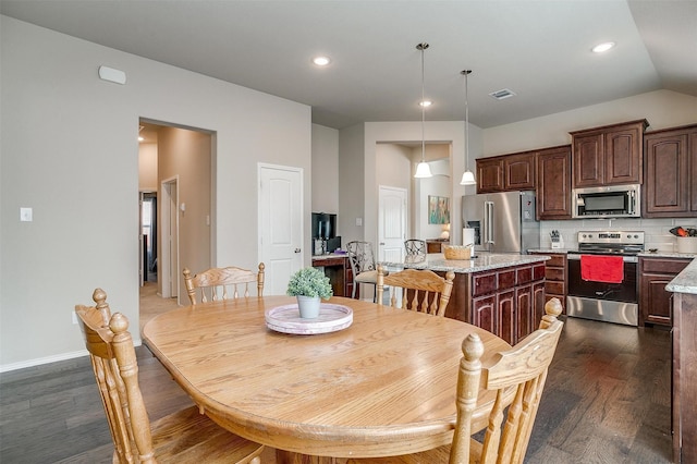 dining room with dark hardwood / wood-style floors and lofted ceiling