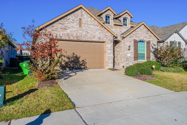 view of front of house featuring central AC unit, a front yard, and a garage