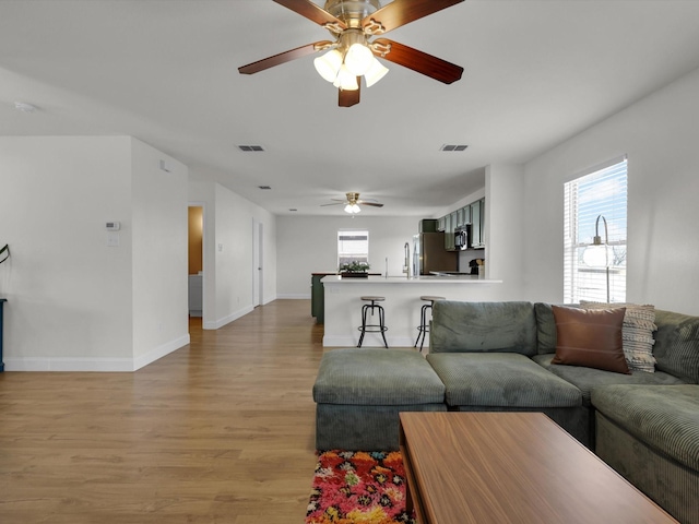 living room featuring light hardwood / wood-style flooring and ceiling fan