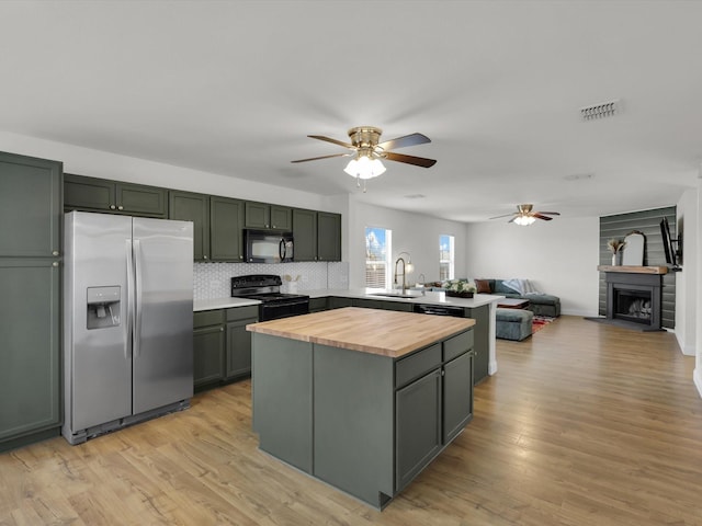 kitchen featuring decorative backsplash, sink, black appliances, and light wood-type flooring