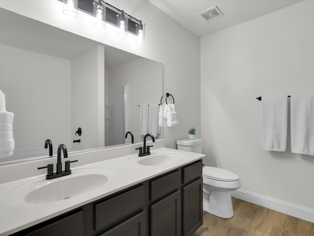 bathroom featuring toilet, vanity, and hardwood / wood-style flooring