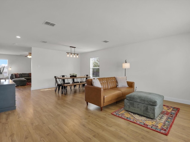 living room featuring ceiling fan and light hardwood / wood-style flooring