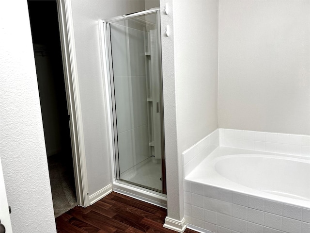 bathroom featuring hardwood / wood-style floors and separate shower and tub