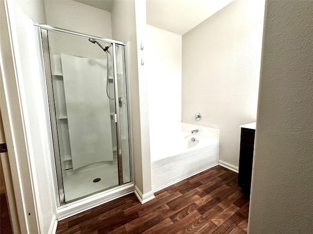 bathroom featuring wood-type flooring, vanity, and shower with separate bathtub