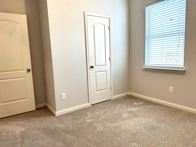 unfurnished bedroom featuring multiple windows and light carpet