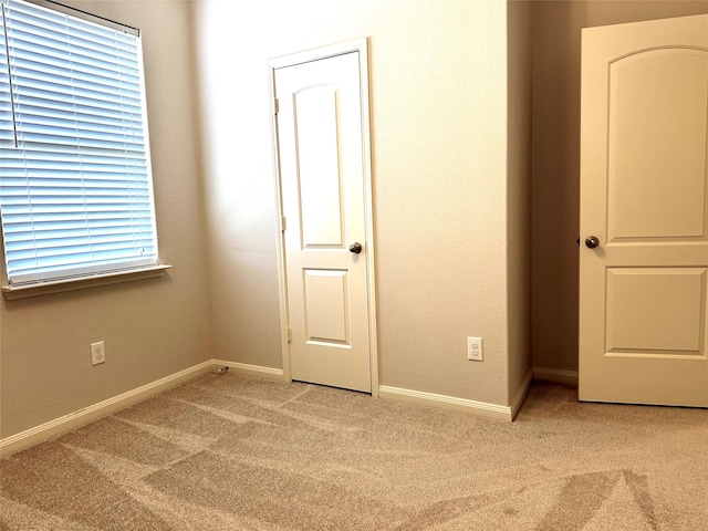 unfurnished bedroom with light colored carpet