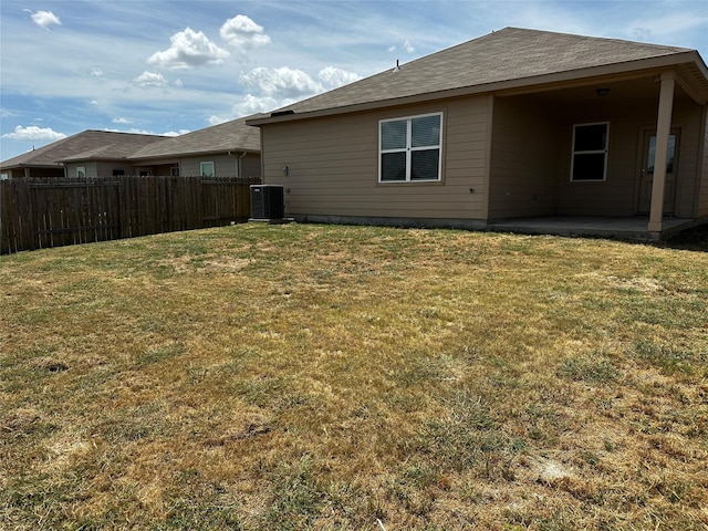 back of property featuring central AC unit, a patio area, and a lawn