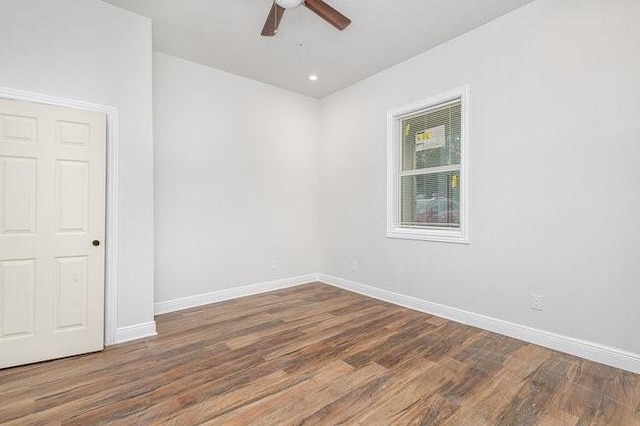 empty room featuring ceiling fan and dark hardwood / wood-style flooring