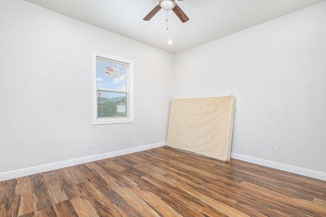 unfurnished room featuring ceiling fan and dark wood-type flooring