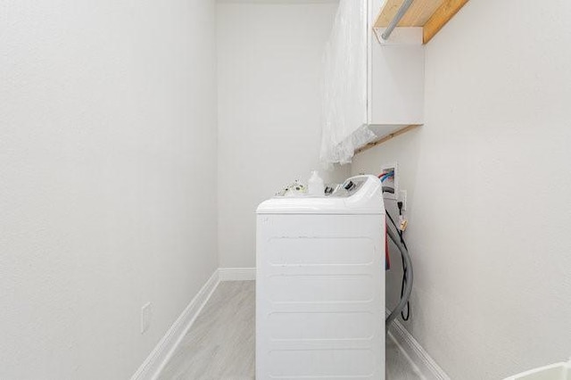 washroom featuring washer / clothes dryer and light hardwood / wood-style flooring