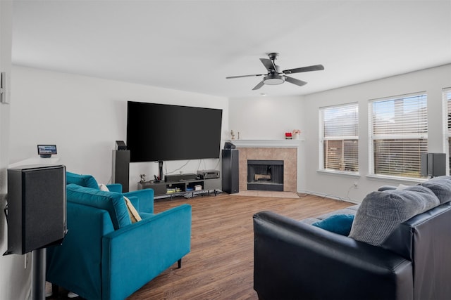 living room with hardwood / wood-style flooring, a tile fireplace, and ceiling fan