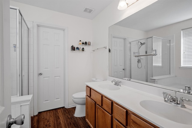 bathroom featuring vanity, toilet, a shower with shower door, and wood-type flooring