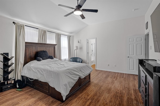 bedroom with hardwood / wood-style flooring, ceiling fan, lofted ceiling, and ensuite bath