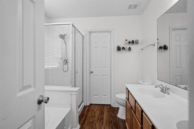 full bathroom featuring vanity, hardwood / wood-style flooring, independent shower and bath, and toilet