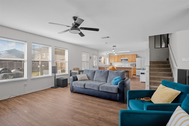 living room featuring ceiling fan and light wood-type flooring