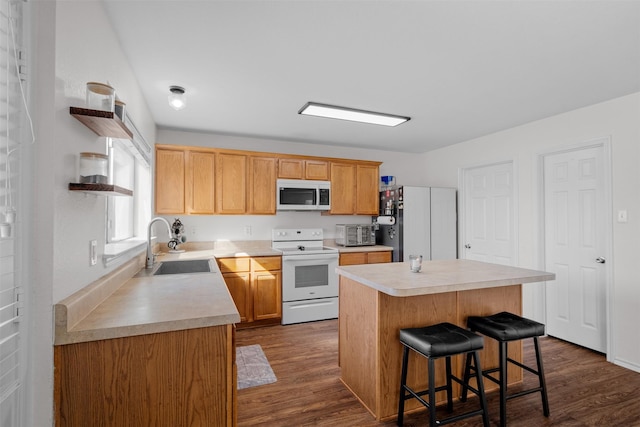 kitchen with sink, stainless steel fridge, white range with electric cooktop, a kitchen island, and a kitchen bar