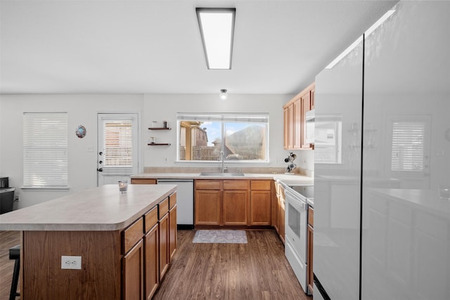 kitchen with dark wood-type flooring, white electric range oven, sink, dishwasher, and a kitchen island