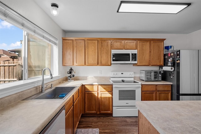 kitchen featuring appliances with stainless steel finishes, sink, and dark hardwood / wood-style floors