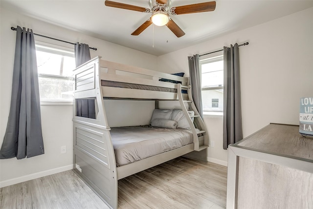 bedroom with multiple windows, ceiling fan, and light hardwood / wood-style flooring