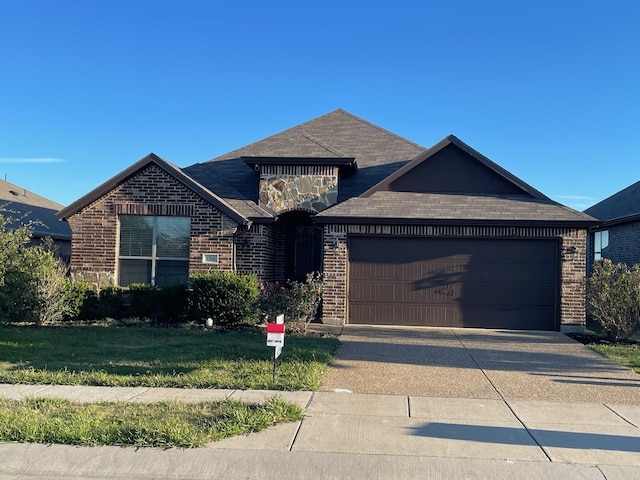 view of front of property with a garage and a front lawn