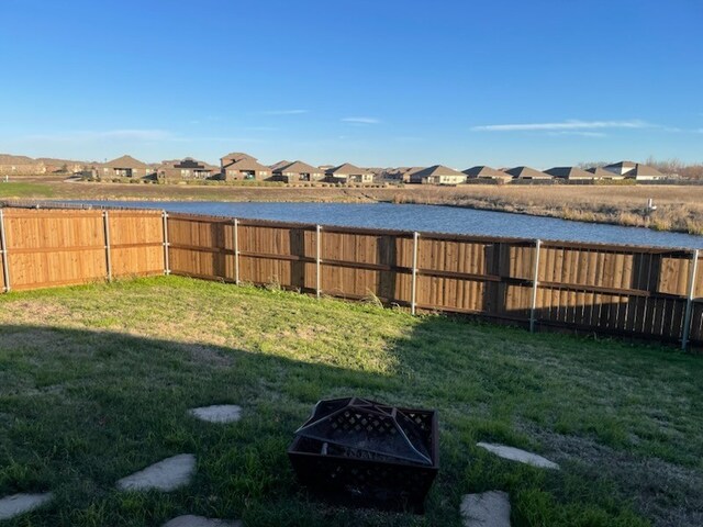 view of yard featuring a water view and an outdoor fire pit