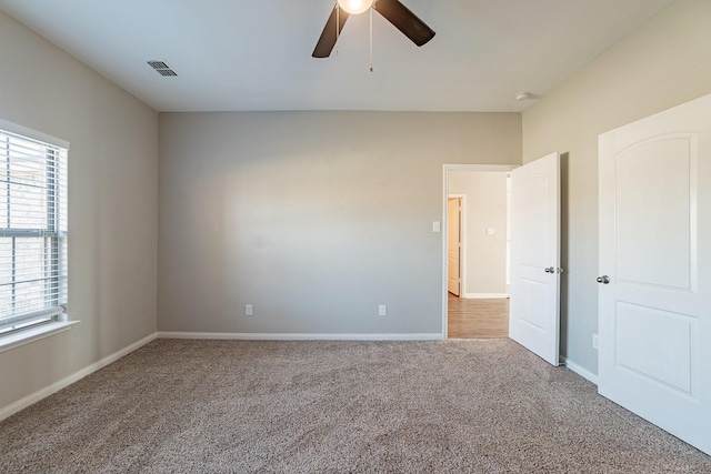 empty room with ceiling fan and carpet floors