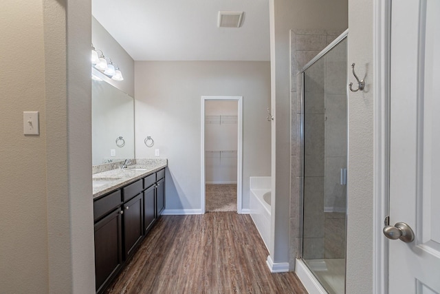 bathroom featuring plus walk in shower, vanity, and hardwood / wood-style flooring