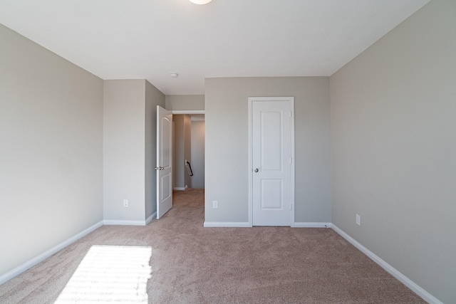 unfurnished bedroom featuring a closet and light colored carpet